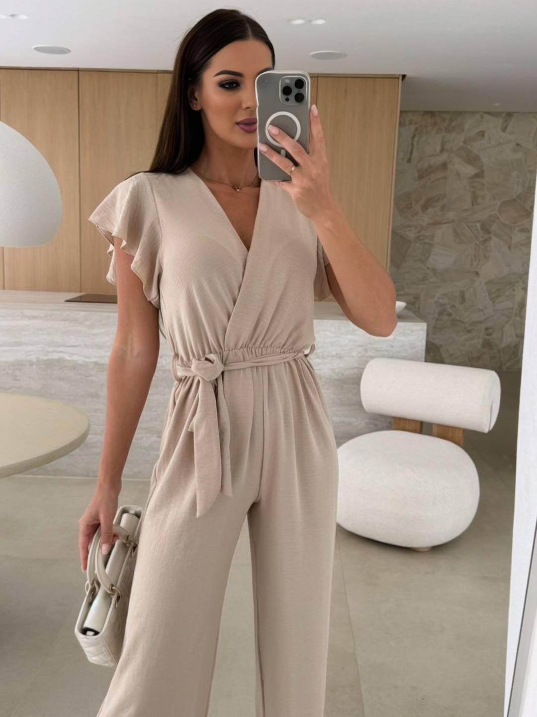 Rochelle Dámsky overal – elegantný jednofarebný overal s výstrihom do V, opaskom a širokými nohavicami s volánmi